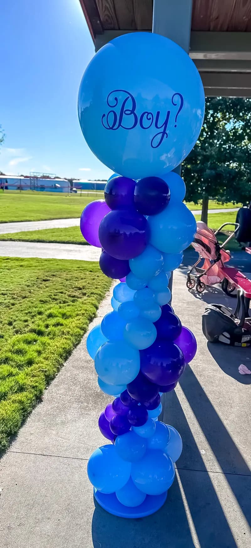 Blue and purple balloon column topped with a 'Boy?' balloon for a gender reveal