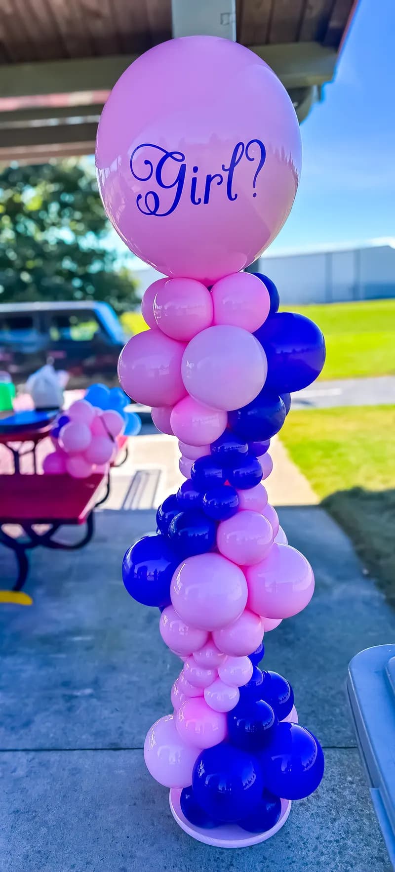 Pink and purple balloon column topped with a 'Girl?' balloon for a gender reveal